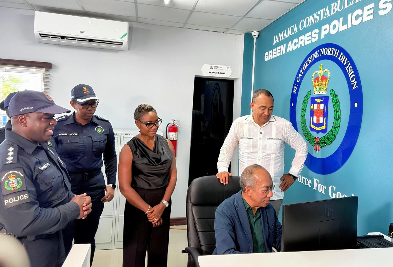 Deputy Prime Minister and Minister of National Security, the Hon. Dr. Horace Chang peruses the computer monitor, while Health Minister and Member of Parliament for West Central St. Catherine, Dr. the Hon. Christopher Tufton (right), Minister of State in the Ministry of National Security, the Hon. Juliet Cuthbert-Flynn (centre), Deputy Commissioner of Police, Karina Powell-Hood and Acting Superintendent of Police, Joel Hamilton from the Property Management and Maintenance Division (Jamaica Constabulary Force