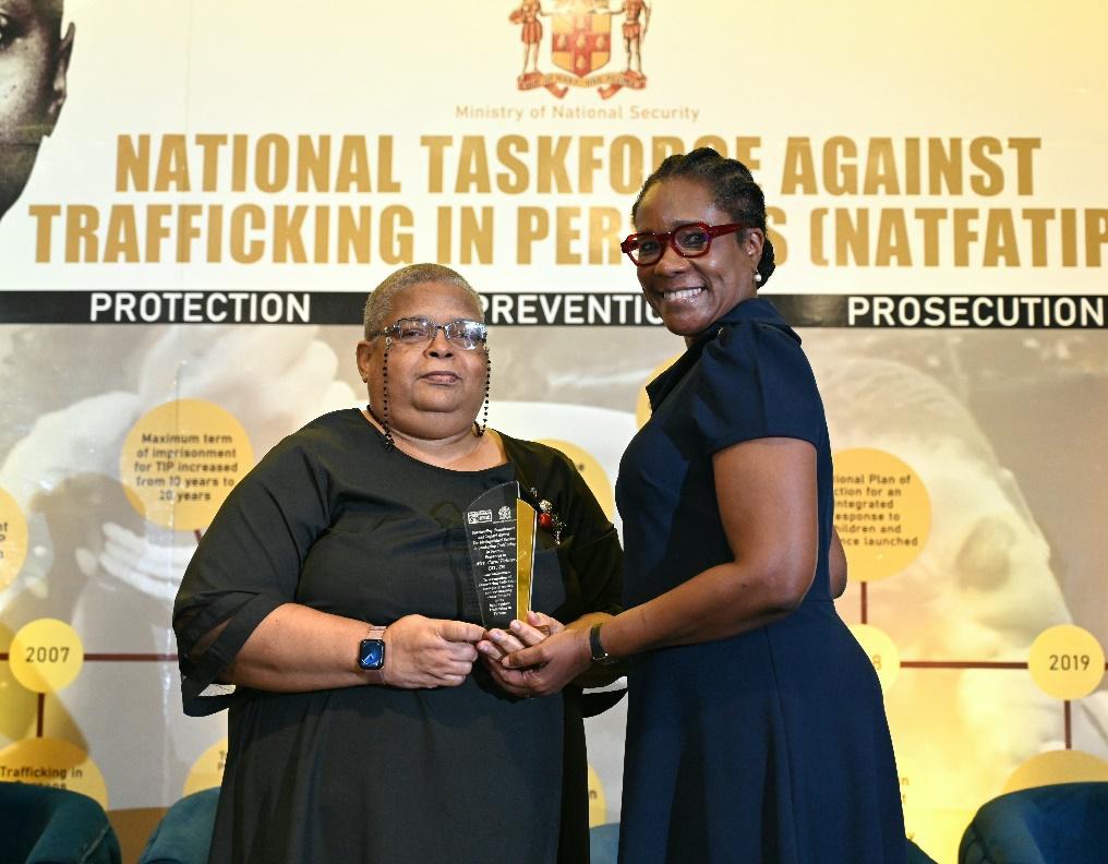 Permanent Secretary in the Ministry of National Security, Ambassador Alison Stone presents Permanent Secretary in the Ministry of Science, Energy, Telecommunications and Transport, Mrs. Carol Palmer with an award for Exemplary Service, Visionary Leadership and Pioneering Efforts in the fight against Trafficking in Persons. The presentation was made at the Caribbean Trafficking in Persons (CariTIP) Forum held at the Dreams Rose Hall Resort and Spa in Montego Bay, St. James earlier today (July 30) in observan