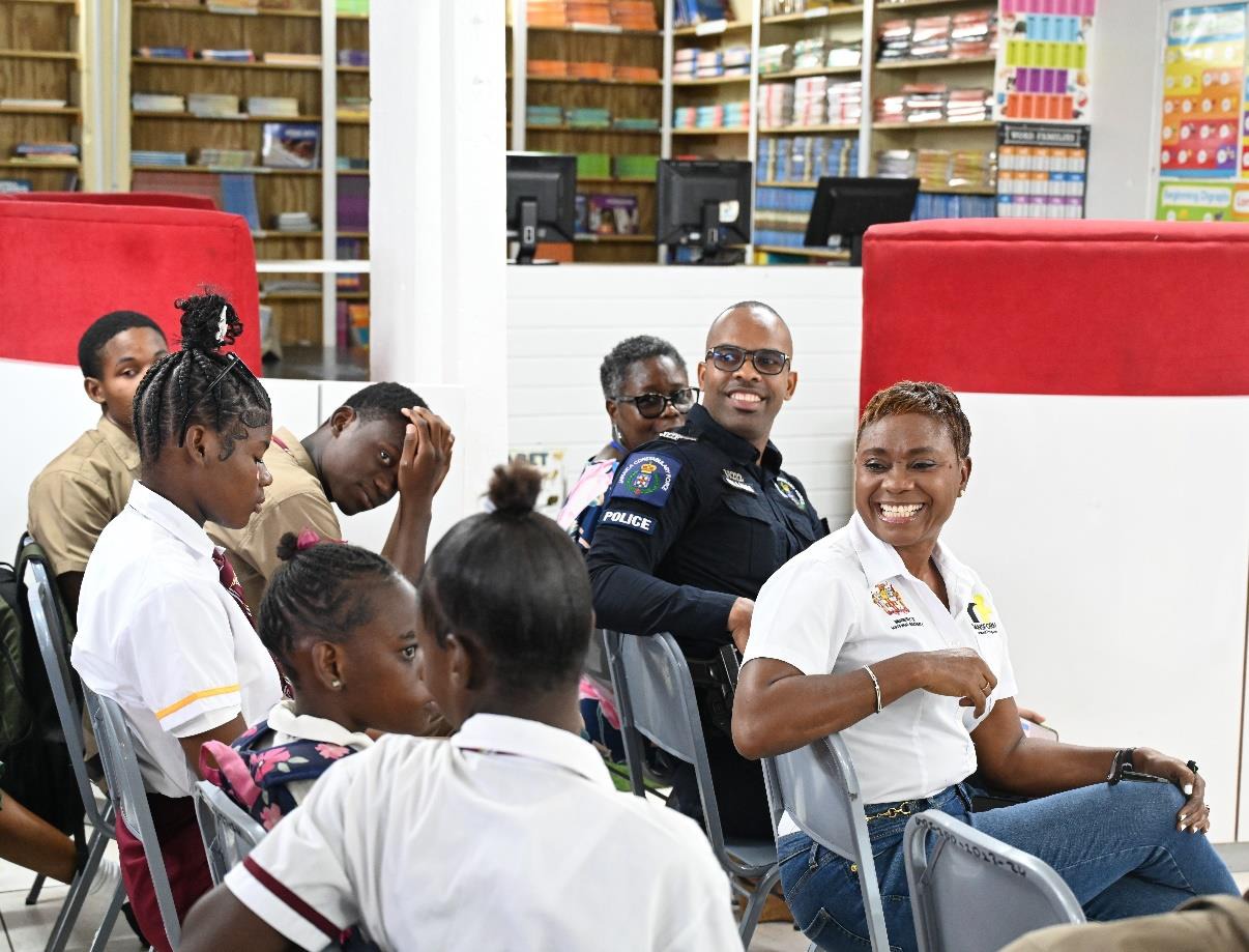 Minister of State in the Ministry of National Security, the Hon. Juliet Cuthbert-Flynn and Sergeant Andrew Williams of the Community Safety and Security Branch of the Jamaica Constabulary Force look on with excitement as students at the Denham Town High School interact during the first session of Ministry’s LIV GUD School Invasion earlier today (September 20).