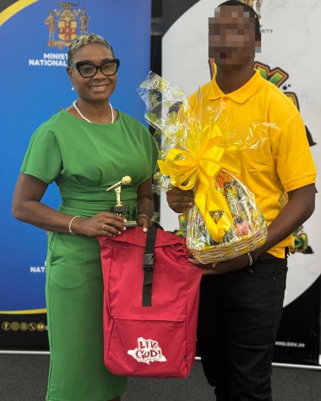 Minister of State in the Ministry of National Security and Peace, the Hon. Juliet Cuthbert-Flynn, presents a ward from the Rio Cobre Juvenile Correctional Centre with prizes at the Ministry’s LIV GUD Jingle Competition Awards Ceremony, held at the Metcalfe Street Secure Juvenile Correctional Centre, on Tuesday, March 24, 2026.