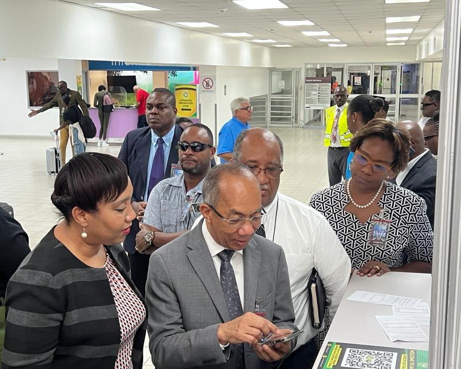 Deputy Prime Minister and Minister of National Security, the Hon. Dr. Horace Chang demonstrates the registration process for the new C5 Electronic Immigration/Customs Declaration (C5) Form at the Norman Manley International Airport on Tuesday, September 5, 2023. Looking on are Permanent Secretary in the Ministry of National Security, Ambassador Alison Stone Roofe (third left), Chief Executive Officer of the Passport, Immigration and Citizenship Agency, Mr. Andrew Wynter and the Commissioner of Customs, Mrs.