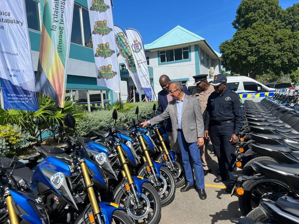 Deputy Prime Minister and Minister of National Security, the Hon. Dr. Horace Chang (foreground)), Deputy Commissioner of Police in charge of Crime Fitz Bailey (left), Deputy Commissioner of Police in charge of Force Development and Logistics Dr. Kevin Blake (right) and Assistant Commissioner of Police in charge of the Public Safety and Traffic Enforcement Branch (PSTEB) inspects one of the seventy-four (74) motorcycles handed over to the Jamaica Constabulary Force at the Office of the Commissioner of Police