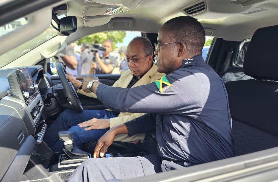 Deputy Prime Minister and Minister of National Security, the Hon. Dr Horace Chang (left), observes as Police Commissioner Dr Kevin Blake demonstrates a feature in one of the brand new motor vehicles handed over to the Jamaica Constabulary Force on Wednesday, February 19. The new fleet comprises a total of 274 vehicles and motorcycles.