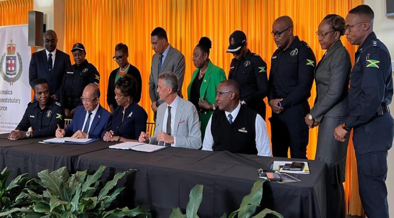 Deputy Prime Minister and Minister of National Security, the Hon. Dr Horace Chang (seated 2nd left), signs the contract to officially mark the beginning of the construction of the new St Catherine North Police Divisional Headquarters at the signing ceremony at Jamaica House yesterday (June 23). Also affixing their names to the documents were Permanent Secretary in the Ministry of National Security, Ambassador Alison Stone Roofe (seated 3rd left) and Peter Melhado, Chairman WIHCON Ltd. Prime Minister, the Mo