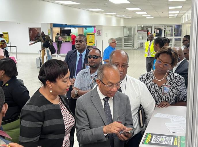 Deputy Prime Minister and Minister of National Security, the Hon. Dr. Horace Chang demonstrates the registration process for the new C5 Electronic Immigration/Customs Declaration (C5) Form at the Norman Manley International Airport on Tuesday, September 5, 2023. Looking on are Permanent Secretary in the Ministry of National Security, Ambassador Alison Stone Roofe (third left), Chief Executive Officer of the Passport, Immigration and Citizenship Agency, Mr. Andrew Wynter and the Commissioner of Customs, Mrs.