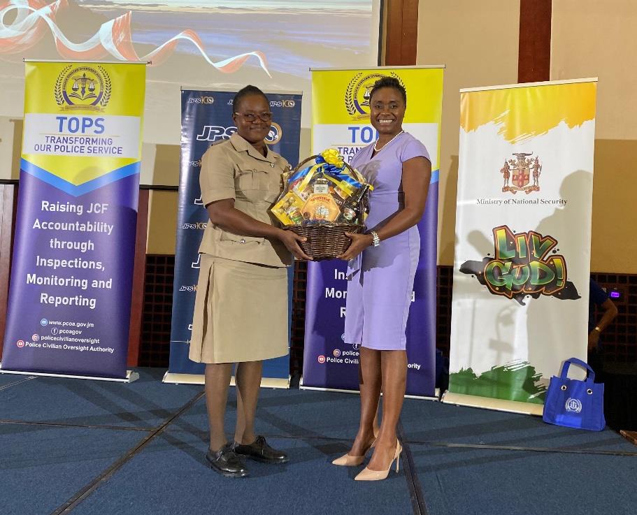 Minister of State in the Ministry of National Security, Hon. Juliet Cuthbert-Flynn hands over a gift basket to Inspector Shawn Whyte from the Montego Bay Police Station. The station copped the award for Top Prisoners in Custody at the Transforming Our Police Service (TOPS) Award Ceremony today (November 22).