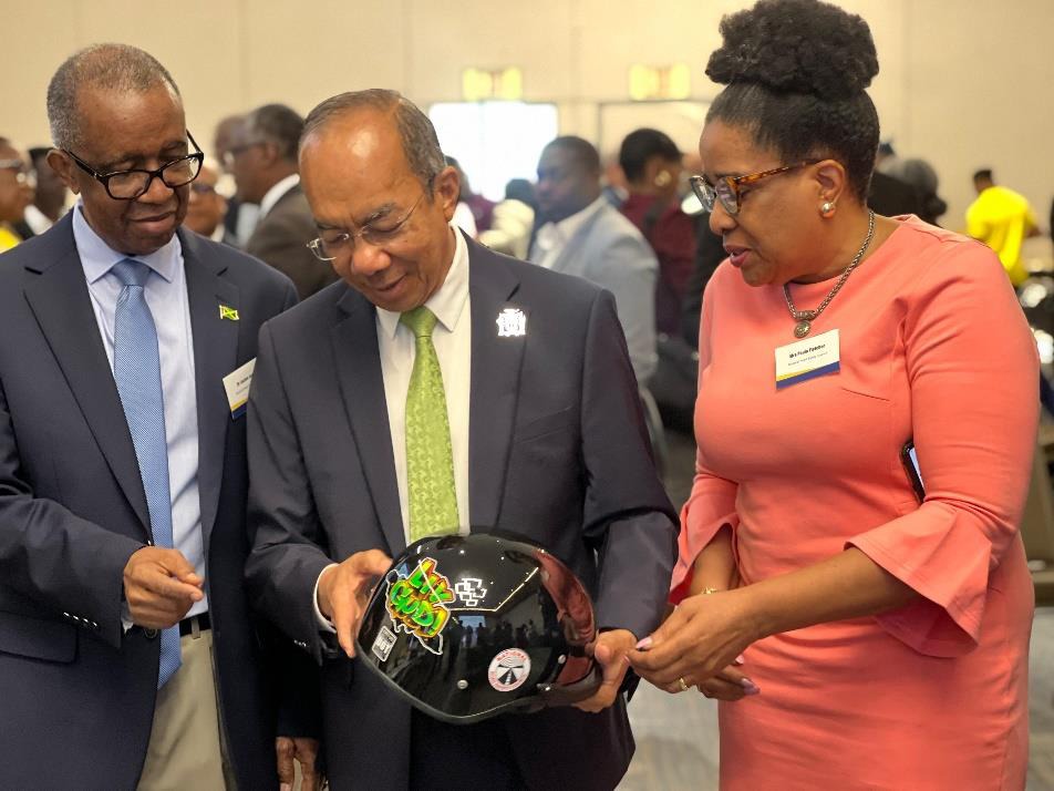 Deputy Prime Minister and Minister of National Security, the Hon. Dr. Horace Chang (centre), Vice Chairman of the National Road Safety Council, Dr. Lucien Jones and Executive Director of the National Road Safety Council, Mrs. Paula Fletcher inspect one of the helmets at the launch of the National Helmet Wearing Coalition Project held at the AC Hotel by Marriott earlier today (March 21).