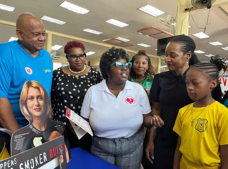 Chief Technical Director in the Ministry of National Security, Shauna Trowers (second left), Executive Director of the National Council on Drug Abuse, Michael Tucker (first left) look on as Minister of State in the Ministry of Education and Youth, the Hon. Marsha Smith (second right) engages in a discussion with Marketing Officer at the Heart Foundation, Sandreen McVoitte (centre) at the Opening Ceremony for an expo in recognition of World No Tobacco Day. The event was held at the Pembroke Hall Primary Scho