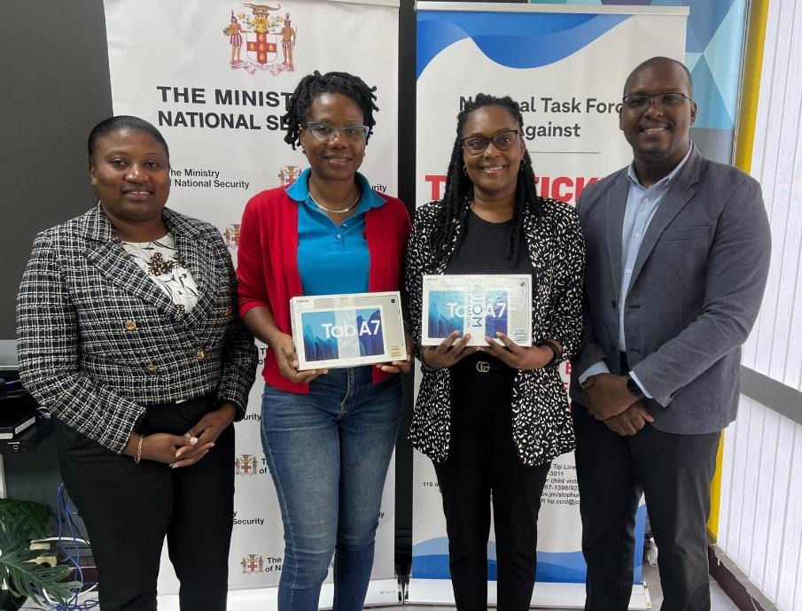 Chief Technical Director in the Ministry of National Security, Michael Morgan (first right), Head of Office, International Organization for Migration Dominica, Natasha Greaves (first left) share a moment with Head of the Anti-Trafficking in Persons Unit, Counter-Terrorism and Organised Crime Investigation Branch in the Jamaica Constabulary Force, Detective Inspector Kemisha Gordon (second left) and Victims Services Officer, Victim Support Division in the Ministry of Justice, Leah Miles at the handover of tw