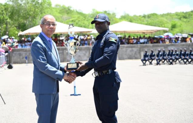 Deputy Prime Minister and Minister of National Security, the Hon. Dr. Horace Chang presents Constable Krisano Christie with the award for Best All Round Performance at the Passing Out Parade and Awards Ceremony for Batch 153, at the National Police College of Jamaica in Twickenham Park, St. Catherine yesterday (June 25). A total of 195 freshly minted constables matriculated into the Jamaica Constabulary Force.