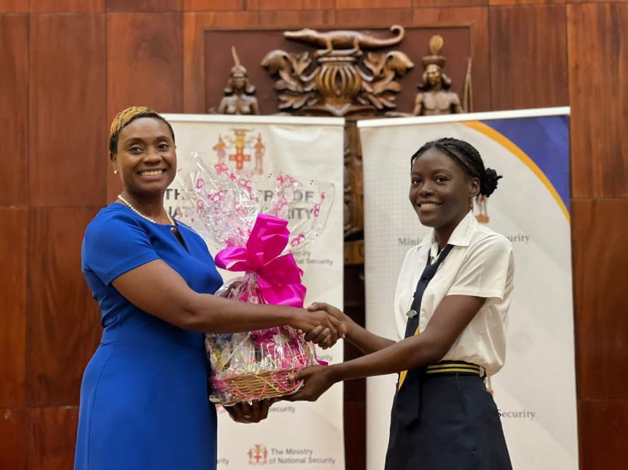 Minister of State in the Ministry of National Security, the Hon. Juliet Cuthbert-Flynn presents St. Elizabeth Technical High School student, Niomie Morgan with a gift basket for finishing 2nd in the Secondary Schools Category of the SheSecures Jamaica Virtual Cyber Competition, which took place from March 20-22, 2024. The Awards Ceremony was held at the Banquet Hall, Office of the Prime Minister earlier today (April 18).